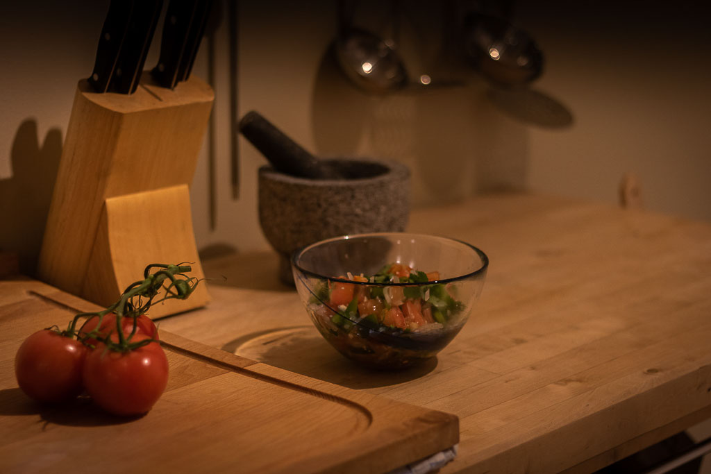 bord med salsa i skål, ferske tomater i en klase på ei trefjøl