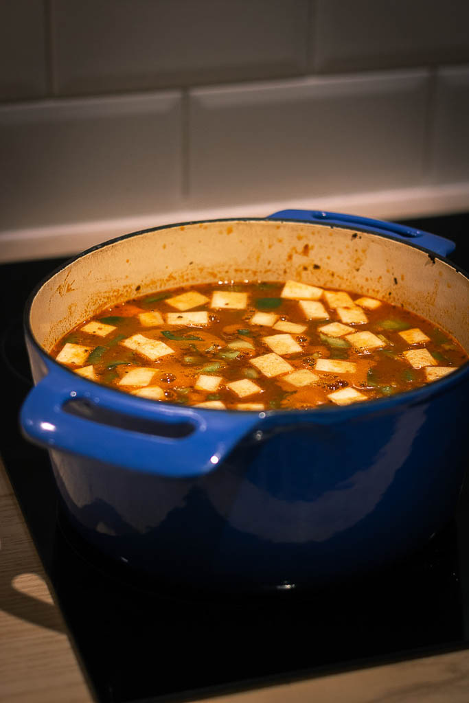 Kjele stående på komfyren med putrende gulasjsuppe