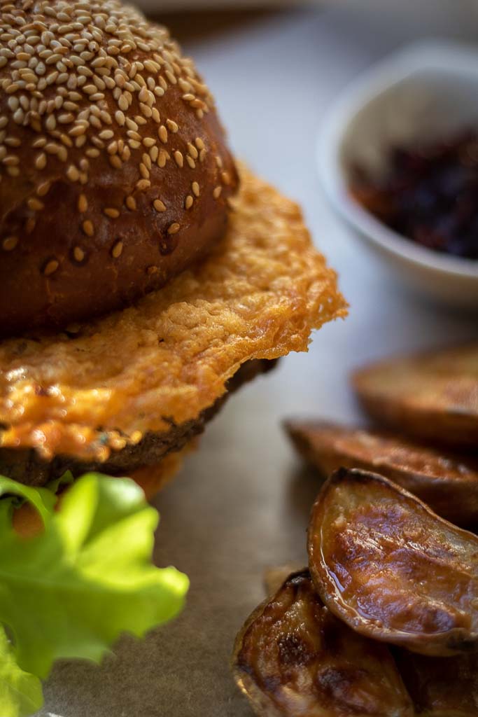 nærbilde av stekt parmesanchips i en burger