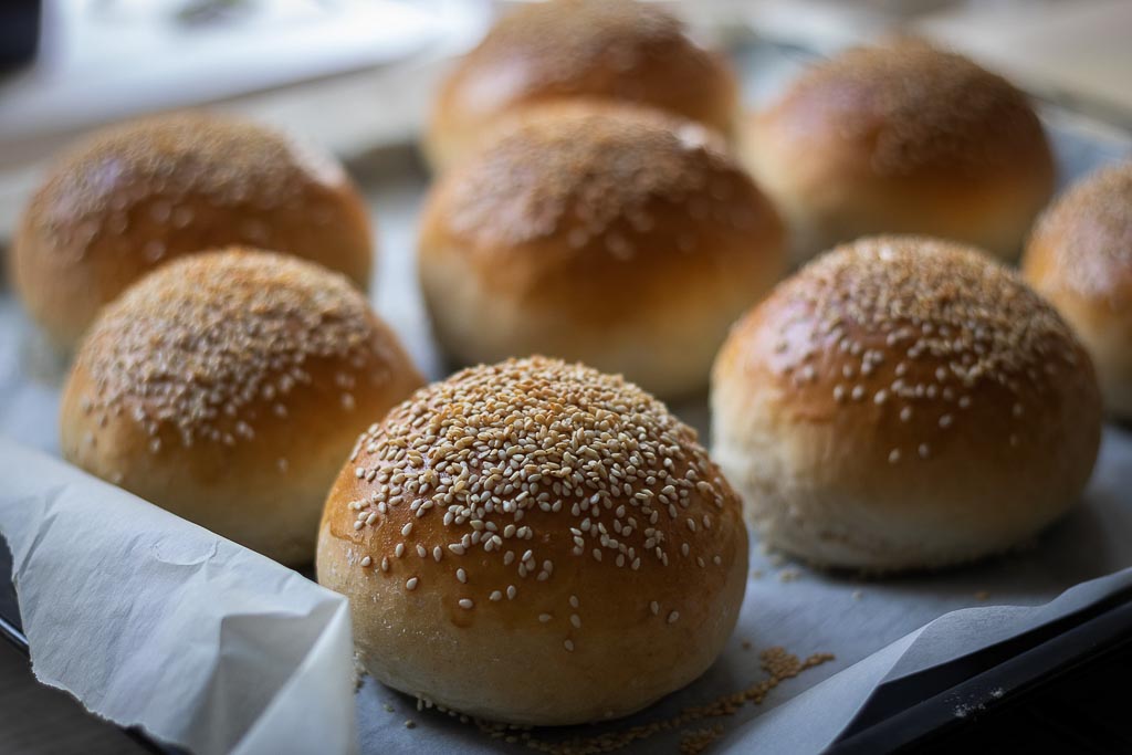 ferdigstekte hamburgerbrød med sesamfrød på et stekebrett