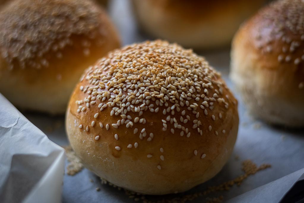 ferdigstekte hamburgerbrød med sesamfrød på et stekebrett