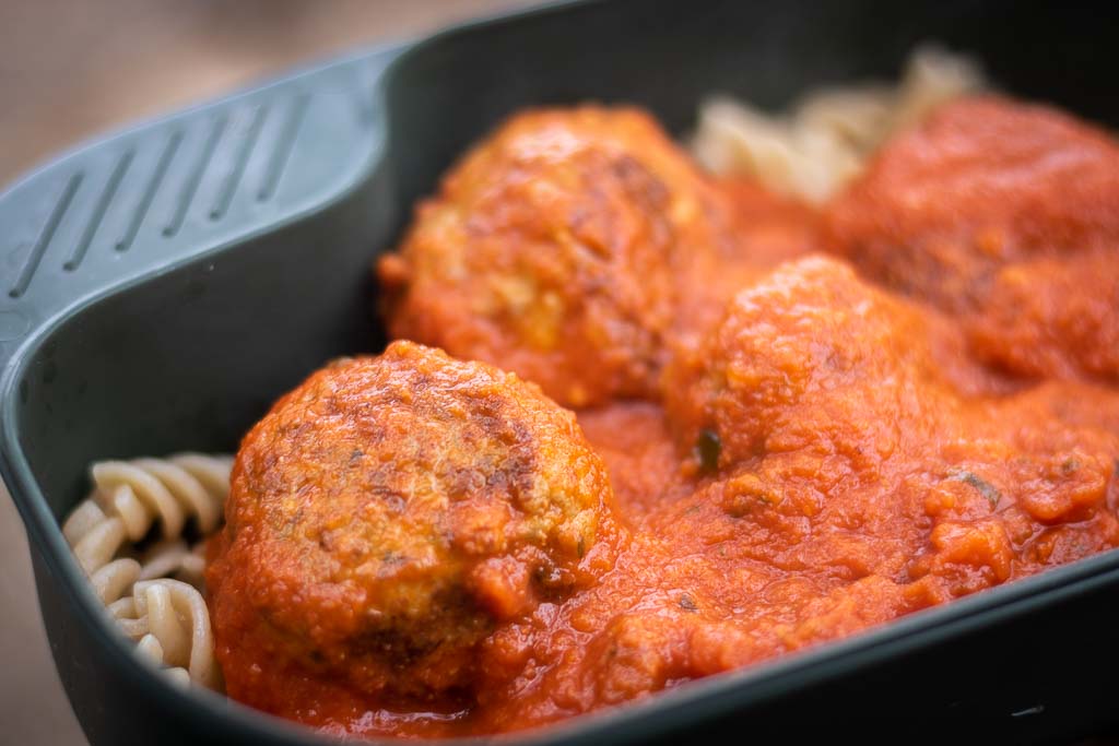 Kjøttboller med tomatsaus og pasta i en turtallerken